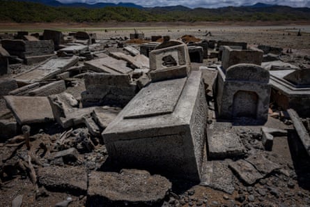 Tombstones and sarcophaguses muddled together amid dried mud.