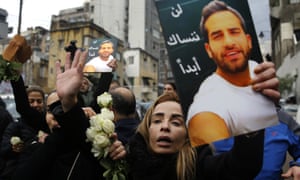 The sister of Elias Wardini, a Lebanese man killed in the nightclub attack, mourns as she holds her brother’s portrait during his funeral procession