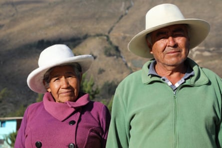 An elderly man and woman, both wearing white broad-brimmed hats
