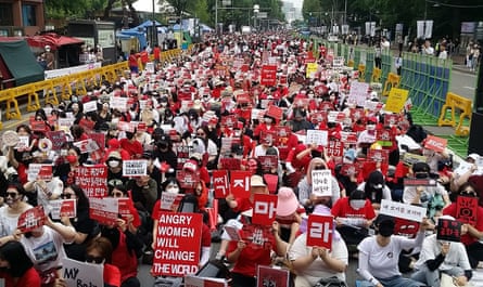 huge crowd of people carrying red signs