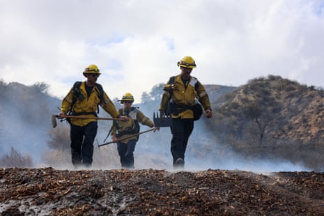 Firefighters walk to a ridge while fighting the Bike fire in the outskirts of Santa Clarita, California.
