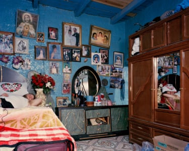 man lying connected furniture astatine home, pinch a assemblage wall of framed pictures supra him