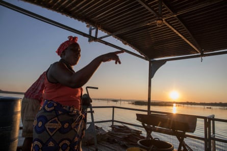 Esnath Munkuli gestures to Talent Siyakanyowa as they set out for a night of fishing on the Zambezi River