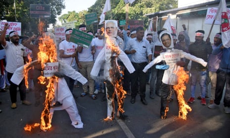 Activists in Guwahati, in Assam, burn effigies of Narendra Modi, centre, and other politicians