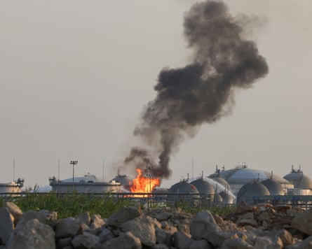 Flames and thick black smoke rise from AramcoâÂÂs Riyadh refinery, viewed over a rocky field