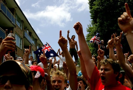 Crowds gathered in a Cronulla street waving Australian flags and holding up their firsts and hands