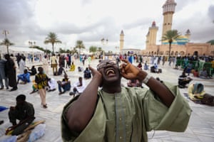 People pray next to the Great Mosque in Touba