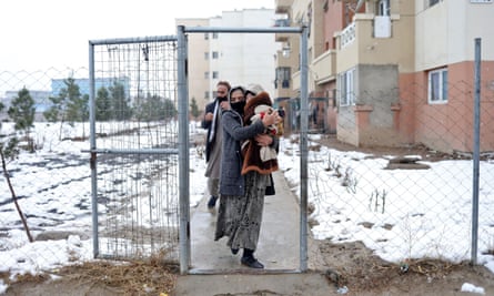 Sohail Ahmadi is carried by his grandmother as they leave the then-house of Hamid Safi