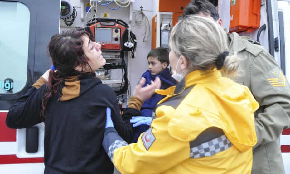 A woman and boy are attended to by a Turkish medical team after a boat sank in the Aegean.