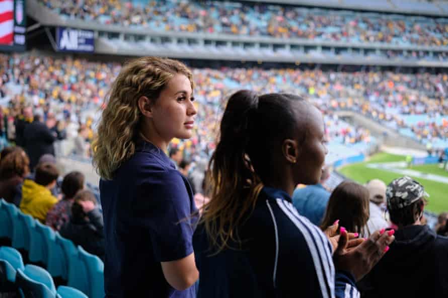 Zahra (à gauche) regarde les Matildas jouer contre les États-Unis au Stadium Australia avec son amie et coéquipière Semi.