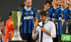 Antonio Conte removes his runners-up medal as he walks past the trophy.