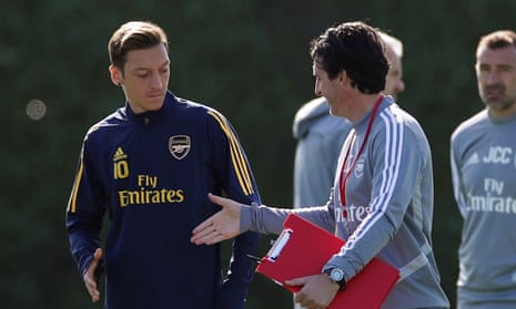 Unai Emery and Mesut Özil share a handshake during Arsenal training but the German will not travel to his homeland for the Europa Cup tie against Eintracht Frankfurt.