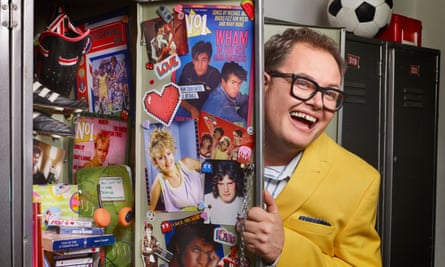 Alan Carr behind a school locker door with stickers of Wham! and other 80s pop stars