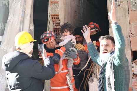Members of a South Korean disaster relief team rescue a toddler in Antakya, Hatay province.