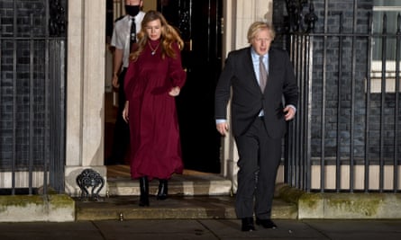 Boris Johnson and Carrie Symonds come out of 10 Downing Street in February 2021 to take part in a national clap for Captain Sir Tom Moore, after his death, and NHS staff.