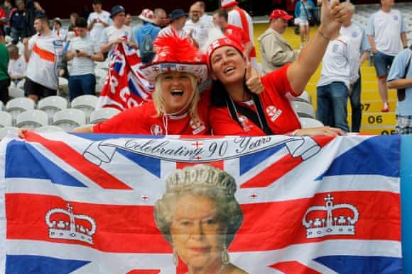 Women wave a Union Jack to celebrate the Queen's 90th birthday.