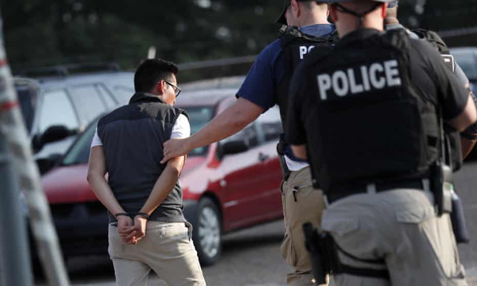 A man is taken into custody at a Koch Foods Inc. plant in Morton, Mississippi, on Wednesday.