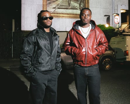 The rappers Ceebo and Blanco standing in a floodlit street