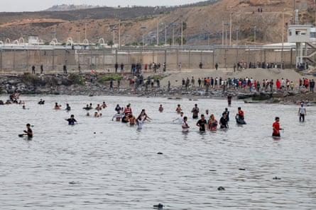 People wade through water to enter the Spanish territory of Ceuta.