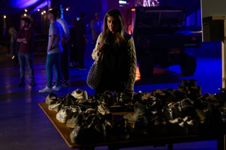 a woman looks at shoes on a table