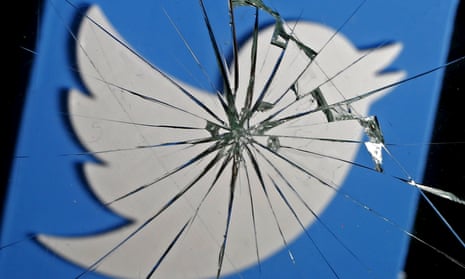 A 3D-printed Twitter logo is seen through broken glass