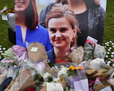Flowers and tributes are piled in remebrance against a photograph of slain Labour MP Jo Cox in parliament square 18 June 2016.