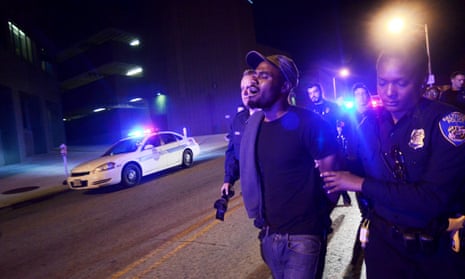 A man is led away by Baltimore police on Saturday night. The man claimed he was on his way home when he was arrested.