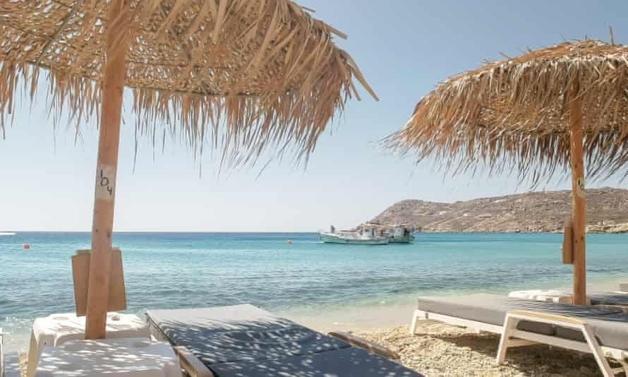 Beach chairs and fishing boats at Elikon Beach, Mykonos