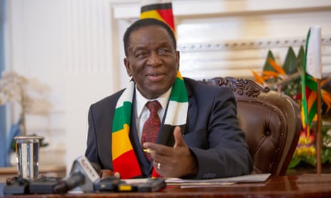 Emmerson Mnangagwa at desk with flag behind him