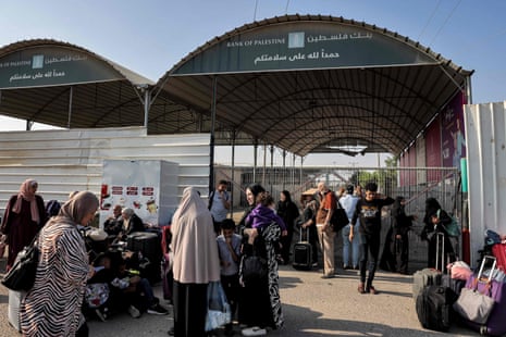 People wait at the Rafah border crossing with Egypt in the southern Gaza Strip on 1 November 2023