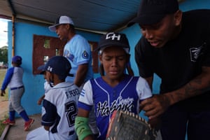 A boy is comforted by his coach Luis Ramirez, 26, during a baseball match