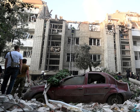 Local residents watch as first responders operate at a residential building partially destroyed as a result of Russian missile strikes in the western Ukrainian city of Lviv.