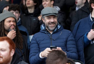 Jason Sudeikis (centre), who writes and stars as the lead role in the hit Apple TV comedy about football manager Ted Lasso watches the match in the home end