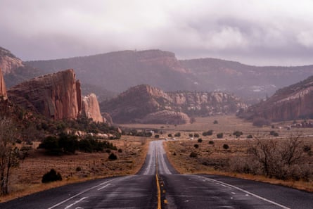 An empty road through dramatic rolling plains