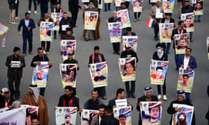 Demonstrators in Baghdad carry the pictures of the victims of protests
