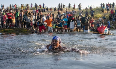 woman is nearly submerged in water as people cross the river