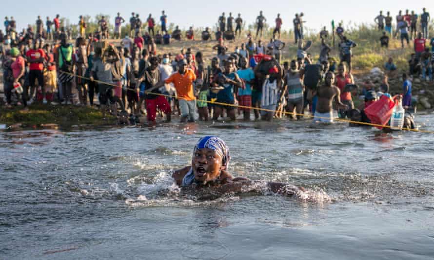 la femme est presque submergée dans l'eau alors que les gens traversent la rivière