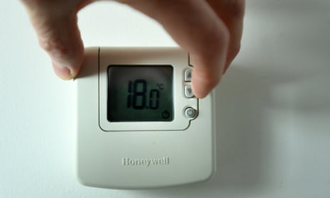 a man turns don the heating thermostat