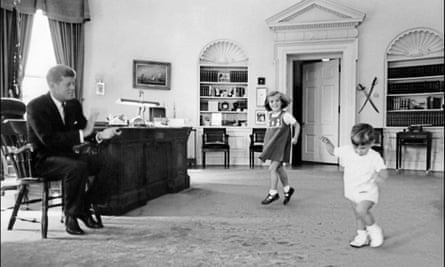 The president watches his children Caroline and John F Kennedy Jr playing in the Oval office.