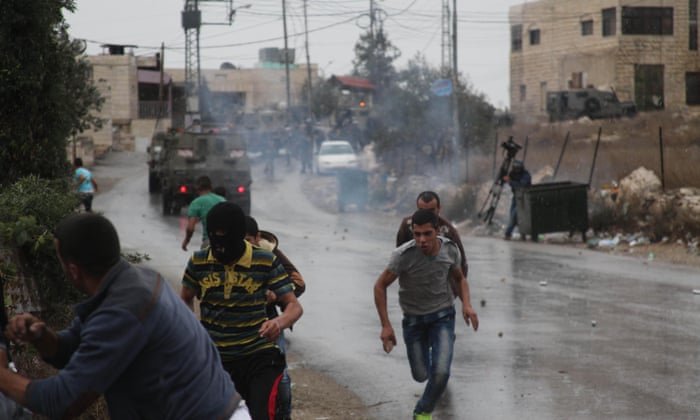 Palestinian protesters run from teargas fired by Israeli soldiers during clashes in the West Bank. Photograph: Emad Drimly/Xinhua Press/Corbis