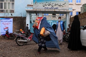 Women receive food rations distributed in Herat, the Afghan city worst affected by coronavirus, on Tuesday