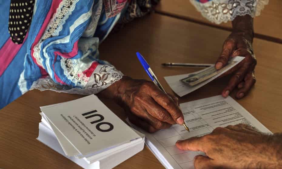 A woman signs before voting in a referendum in Noumea, New Caledonia, 12 December.