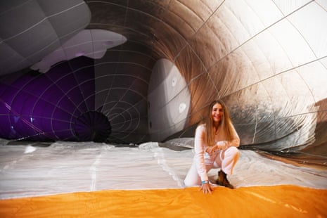 Patricia Piccinini kneeling and smiling inside large balloon structure