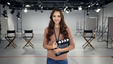 An AI generated image of a woman on a film set smiling and holding a clapperboard.