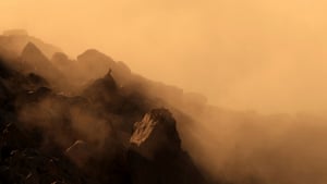 Mist-shrouded mountains with a silhouetted Alpine ibex
