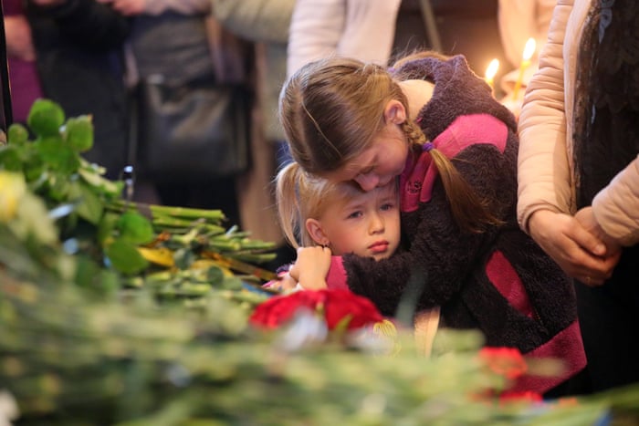 Two children comfort each other as Borovyk’s body is laid to rest.