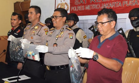 Indonesian police officers display evidence collected during a raid on a gay sauna.