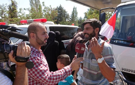 A journalist from Sana holds up a mic to a man in an interview
