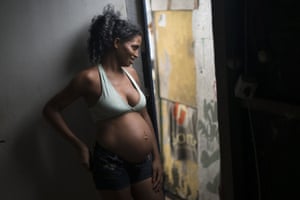 Twenty-one-year-old Tainara Lourenco chats with neighbours at her home in the slum in Recife, Brazil