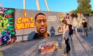 Graffiti Of George Floyd In BerlinBERLIN, GERMANY - MAY 31: People look at a graffiti depicting a portrait of George Floyd, an African-American man who died in Minneapolis after a white policeman kneeled on his neck for several minutes, on a wall at Gedenkstatte Berliner Mauer on May 31, 2020 in Berlin, Germany. (Photo by Peng Dawei/China News Service via Getty Images)